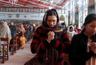 Famílias de cristãos perseguidos na Índia 2026 diante de casas destruídas.